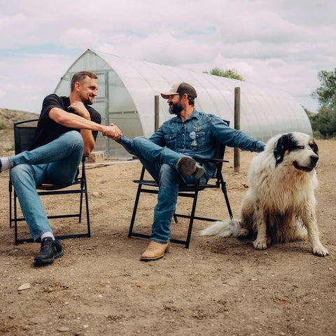 A.J. Richards and Gustavs shaking hands in front of the poly greenhouse on his Wyoming lot
