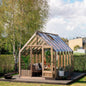 Wooden greenhouse with interior furniture in a garden setting