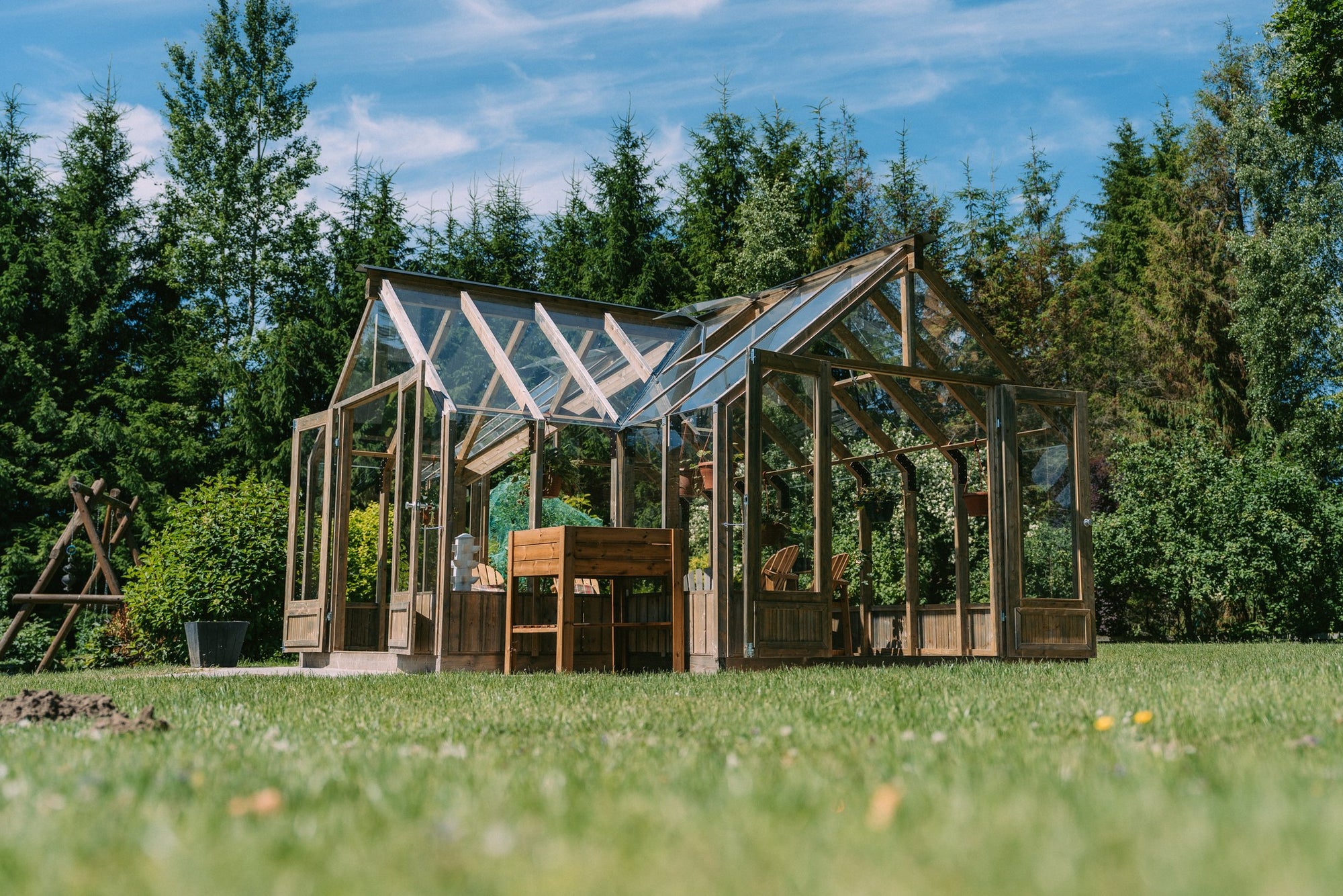 A T-shaped Nordwood greenhouse on the lawn