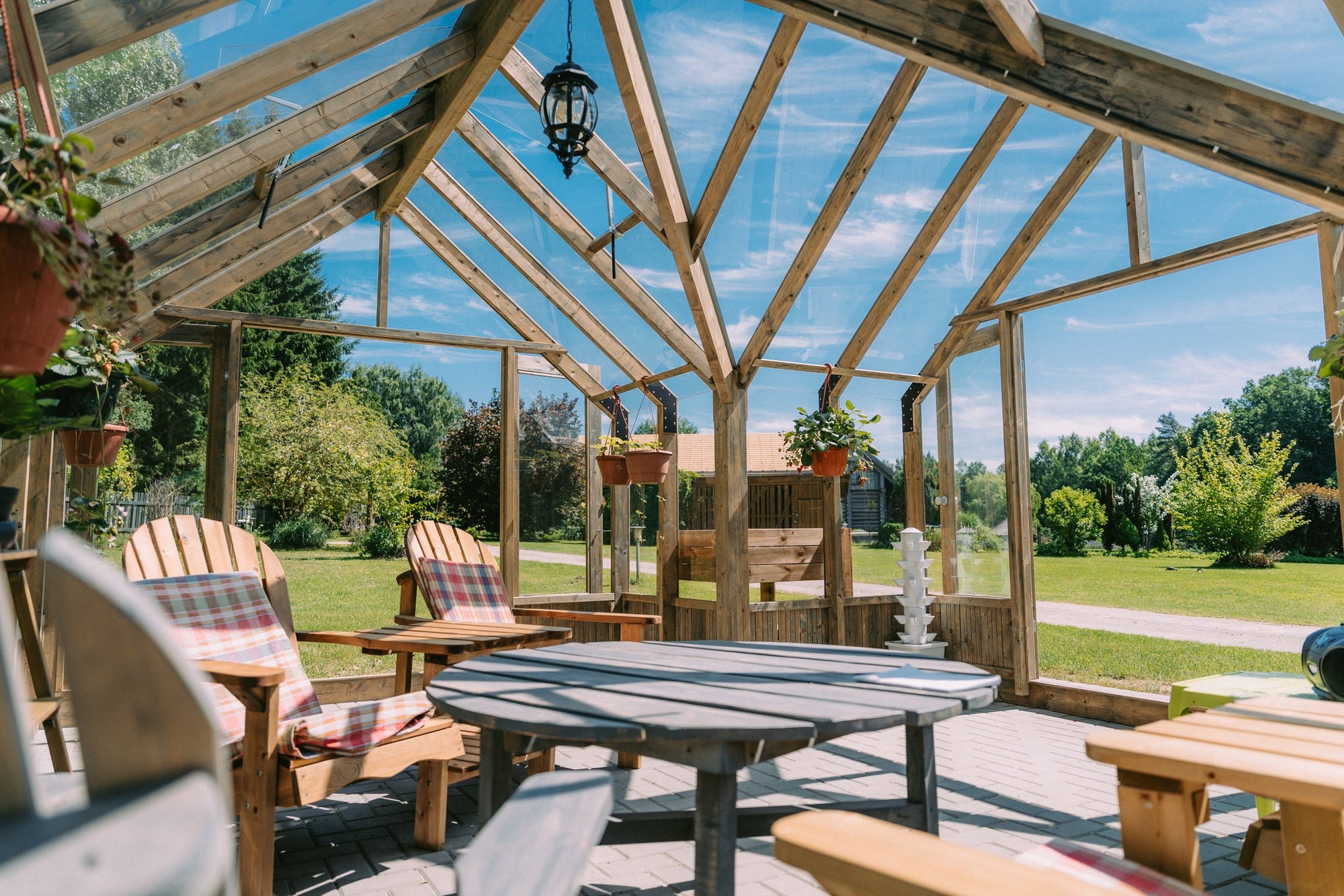 Inside a Nordwood greenhouse, seating around the table under the timber roof