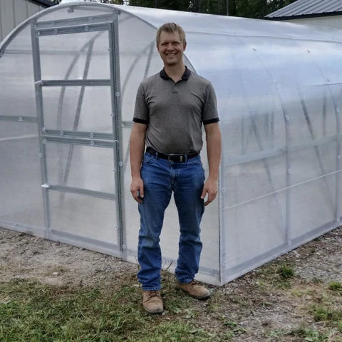 Benjamin, the Montana dealer, with the first sample greenhouse on his lot